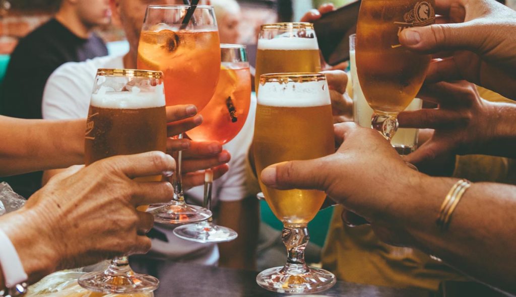 Friends toast to a fun evening out over drinks. Photo by Fred Moon via Unsplash