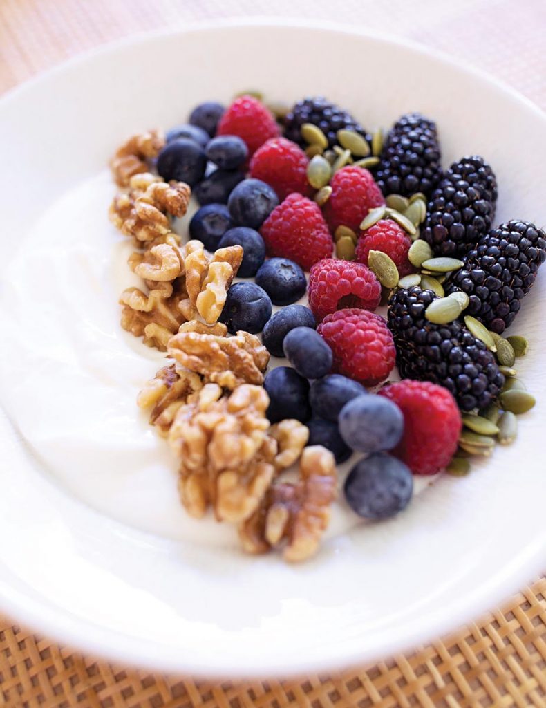 Greek yogurt with nuts, berries, and seeds offers the perfect combination of protein and fiber to combat cravings. Photo by Nathan Coe